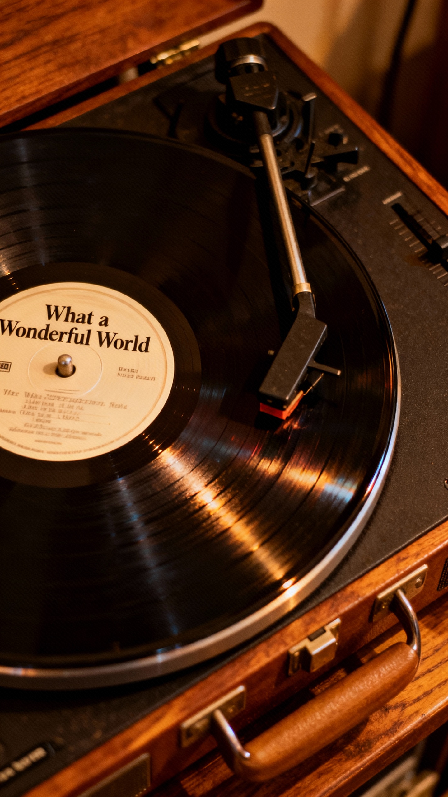 Closeup of vinyl record labeled “What a Wonderful World” spinning on vintage turntable, warm amb